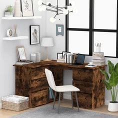 a room with a desk, chair and pictures on the wall next to a potted plant