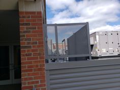 a building with a metal fence next to it and some buildings in the back ground