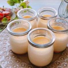 four jars filled with liquid sitting on top of a plate