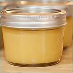 two jars filled with yellow liquid sitting on top of a table