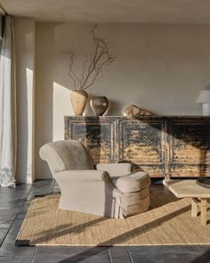 a living room filled with furniture and a large wooden dresser next to a window on top of a hard wood floor