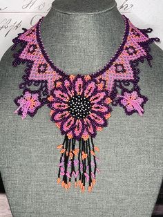 a pink and purple beaded necklace on a mannequin