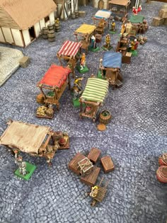 a group of small wooden tables and chairs on a stone floor next to each other