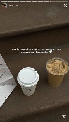 a cup of coffee sitting on top of a set of steps next to a paper