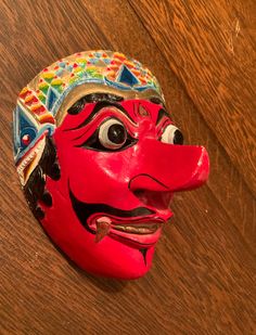 A vibrant and striking mask! Great colors. Elaborate detail. A wood carved mask for Javanese dance. Mask maker Ganuh Nugroho AdiNarimo is highlighted in an article (Javanese Klana 5/25/2017) in Second Face at maskmuseum.org Klana Sewandana (character) is the male antagonist in a love dance. In good condition with some minor chipping as shown in the photos. Enjoy! Traditional Masks And Prosthetics For Carnival, Artistic Red Masks And Prosthetics For Festivals, Traditional Full Face Carnival Masks, Traditional Masks For Masquerade And Festivals, Traditional Carnival Masks And Prosthetics, Traditional Festival Masks And Prosthetics, Traditional Masks And Prosthetics For Masquerade Festivals, Handmade Traditional Mask, Carved Mask