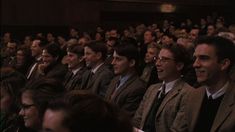 a group of men sitting next to each other in front of a crowd