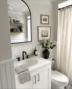 a bathroom with a toilet, sink, and mirror in it's centerpiece