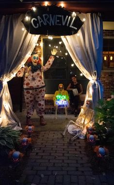 a person dressed as a clown standing in front of a sign with lights on it