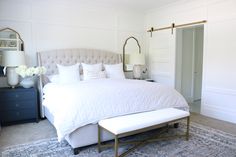 a white bed sitting in a bedroom on top of a rug