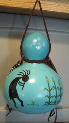 a blue vase hanging from the ceiling with an image of a deer painted on it