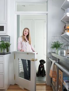 a woman standing at the door to her dog