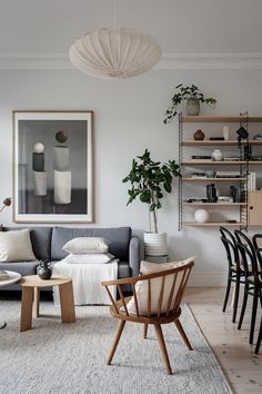 a living room filled with furniture and a painting on the wall over a gray couch