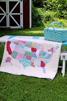 a picnic table with a quilted usa map on it and a basket hanging from the back