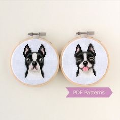 two cross - stitch hoop earrings with a black and white dog on them, one has a pink nose