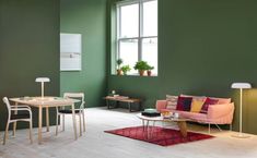 a living room filled with furniture and green walls