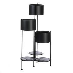 three tiered plant stands with black lamps on each side and round trays underneath them