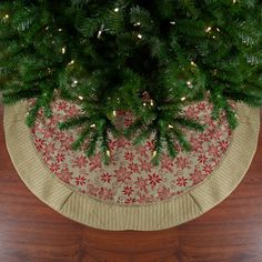 a christmas tree skirt on top of a wooden floor next to a rug with snowflakes