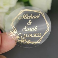 a close up of a person holding a wedding sticker