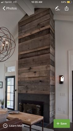 a living room filled with furniture and a fire place in front of a wooden wall