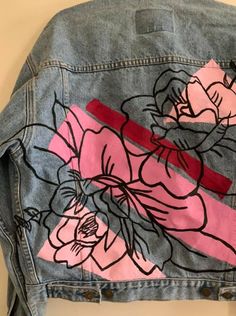 a jean jacket with flowers painted on it