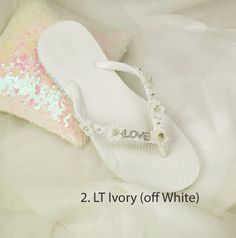 Wedding Lt Ivory Shoes,Bridal Flip Flops,Beach Wedding Shoes,Bridesmaid Slippers ,Floral Wedding Sandals, Rhinestone Flip Flops -SD047 We made with white flat flip flop decorated with Off white Flower .It is shining with a clear crystal on the lace. These flip flops are designed for brides and bridesmaids looking for style. Model shoe size US 8. Quantity:one order is 1 pair (2 pcs). White Sandals With Rhinestones And Adjustable Fit, Summer White Bridal Accessories For Bridal Shower, White Summer Bridal Accessories For Bridal Shower, Summer Bridal Accessories For Bridal Shower, White Bridal Accessories For Summer Bridal Shower, Elegant Rhinestone Flip Flops For Wedding, Elegant Wedding Flip Flops With Rhinestones, White Open Toe Flip Flops For Wedding, White Adjustable Flip Flops For Wedding