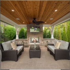 an outdoor living area with couches and tables