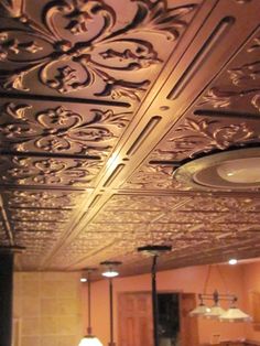 an ornate ceiling in the middle of a room with two lamps on either side of it