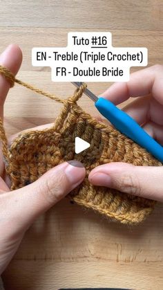 two hands are crocheting together to make a small purse