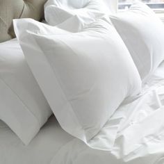 four white pillows are stacked on top of each other