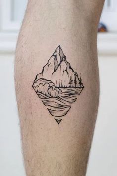 a man's leg with a mountain and lake tattoo on the side of his calf