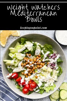 a white bowl filled with salad next to sliced cucumbers