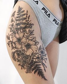 a woman's thigh with flowers and leaves on the bottom half of her leg