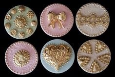 four decorative plates with gold and pink designs on them, each decorated with a bow