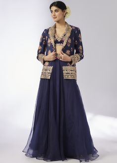 This elegant navy blue lehenga set features a floral embroidered jacket paired with a matching blouse and a flowing skirt. The intricate detailing and sophisticated design make it a perfect choice for festive occasions and weddings. Elegant Lehenga With Floral Embroidery In Traditional Drape, Elegant Lehenga With Floral Embroidery, Elegant Floor-length Skirt Set With Zari Work, Elegant Designer Zari Work Skirt Set, Elegant Skirt Set With Zari Work In Traditional Drape, Elegant Designer Skirt Set With Zari Work, Festive Elegant Saree Skirt Set, Elegant Festive Skirt Set For Reception, Elegant Festive Saree Skirt Set