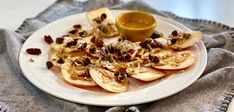 a white plate topped with sliced apples and nuts