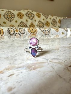 In bloom ring is set with a rose cut ruby, opal and two blue sapphires made in sterling silver. Opal has a pink and blue flash. Ruby has a wonderful opaque glisten and the cut gives it a little sparkle, nestled with the blue sapphires and opal it really sets it off.  US size 6 - can be sized up a bit Pink Sterling Silver Opal Ring For Anniversary, Pink Opal Ring In Sterling Silver For Anniversary, Pink Moonstone Sterling Silver Ring For Anniversary, Pink Sterling Silver Moonstone Promise Ring, Pink Opal Sterling Silver Ring Gift, Pink Opal Ring In Sterling Silver For Gift, Handmade Pink Ruby Ring In Sterling Silver, Unique Handmade Pink Ruby Ring, Handmade Unique Pink Ruby Ring