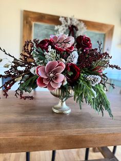 a vase filled with flowers on top of a wooden table