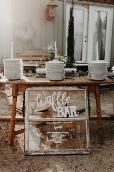 a table with plates and cups on it that says, incorporating rustic wooden accents in white lettering