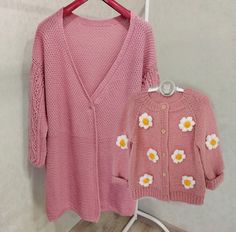 a pink cardigan and sweater with flowers on it