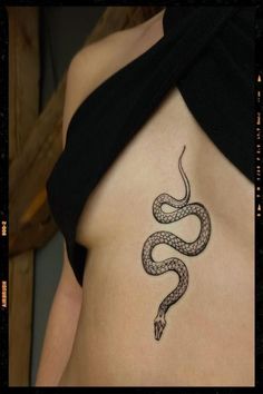 a woman's stomach with a snake tattoo on it