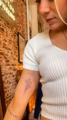 a woman with a flower tattoo on her arm