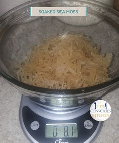 a glass bowl filled with cooked sea moss on top of a digital scale in a kitchen