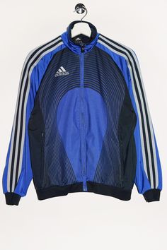 "Vintage Adidas track jacket in blue with a print on the back. - Size tag: Please always check measurements before buying. Youth size L, Fits like Women's S - Measurements (laying flat): Pit to Pit: 21\" Length: 24.5\" Pit to Cuff: 20\" -Wear: /Please see images for details/ Good vintage condition. Fabric snag and burnt spot looking like light stain as shown on the pictures. - Fabric: Polyester *All of our items are preloved pieces so some signs of natural wear and age are to be expected. Please look through the photos carefully to check if the condition is to your satisfaction. *All efforts are made to show any defects however small imperfections may be missed. In cases that we've missed a major flaw, please remember that we are still human and make mistakes, please contact us first so we Vintage Blue Adidas Jacket, Fitted Blue Track Jacket, Blue Sportswear Track Jacket For Fall, Blue Three Stripes Track Jacket For Fall, Blue Track Jacket For Fall Sportswear, Blue Track Jacket For Fall, Blue Sportswear Outerwear With Three Stripes, Blue Streetwear Outerwear With Three Stripes, Blue Stripe Outerwear For Streetwear