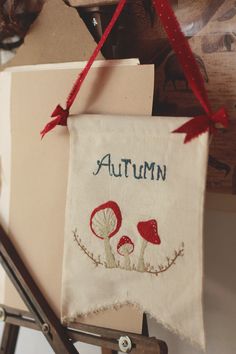 an autumn banner hanging on a wall with scissors and other crafting supplies around it