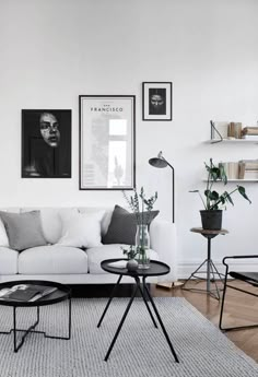 a living room filled with furniture and pictures on the wall