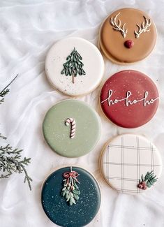 four decorated cookies sitting on top of a white sheet