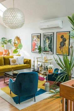 a living room filled with lots of furniture and art work on the wall above it