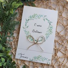 the wedding card is tied with twine and surrounded by greenery