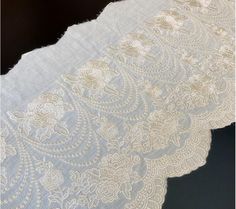 an image of white lace with flowers on it