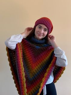 a woman wearing a multicolored knitted shawl